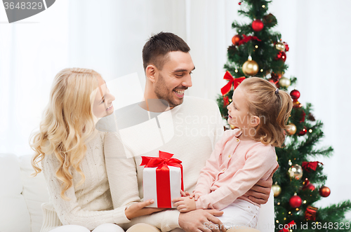 Image of happy family at home with christmas tree