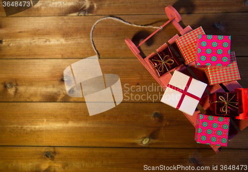 Image of close up of christmas gift boxes on wooden sleigh