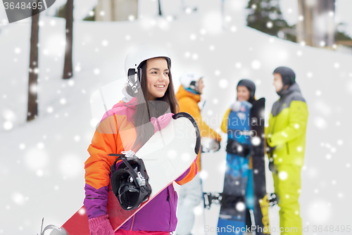 Image of happy friends in helmets with snowboards