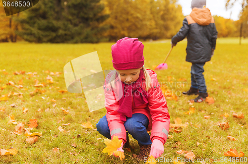 Image of children collecting leaves in autumn park