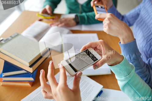 Image of students with smartphones making cheat sheets