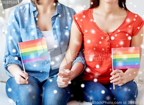 Image of close up of lesbian couple with rainbow flags