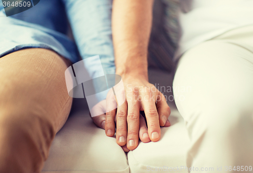 Image of close up of happy male gay couple holding hands