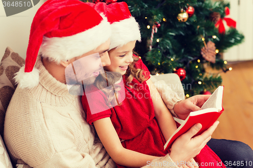 Image of smiling father and daughter reading book