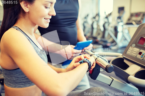 Image of close up of woman setting heart-rate watch at gym