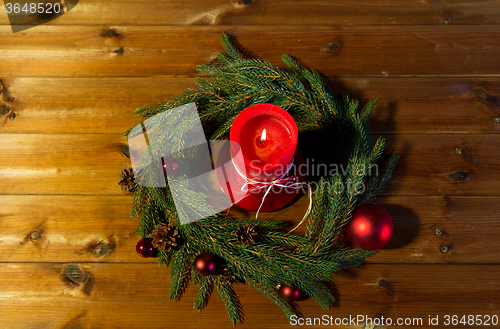 Image of fir branch wreath with candle on wooden table