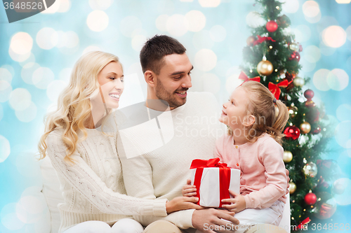 Image of happy family with gift box over christmas lights