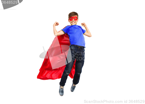 Image of boy in red super hero cape and mask flying on air