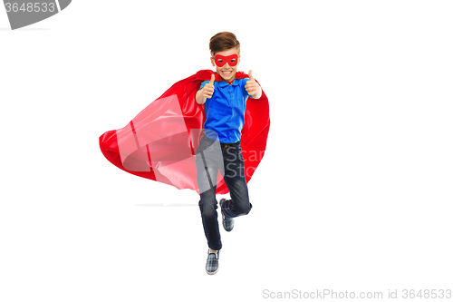 Image of boy in super hero cape and mask showing thumbs up