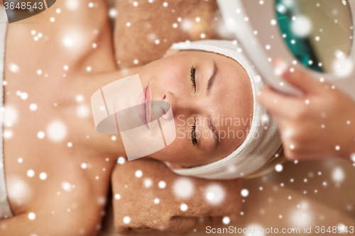 Image of close up of young woman and beautician in spa
