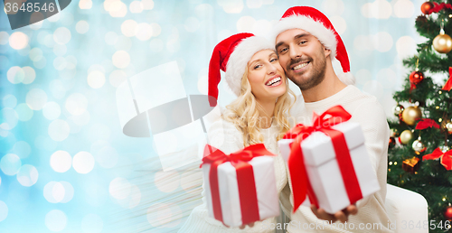 Image of happy couple at home with christmas gift boxes