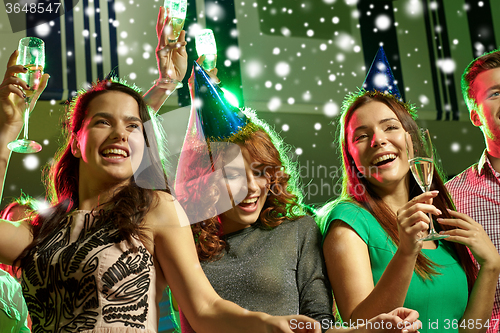 Image of smiling friends with glasses of champagne in club