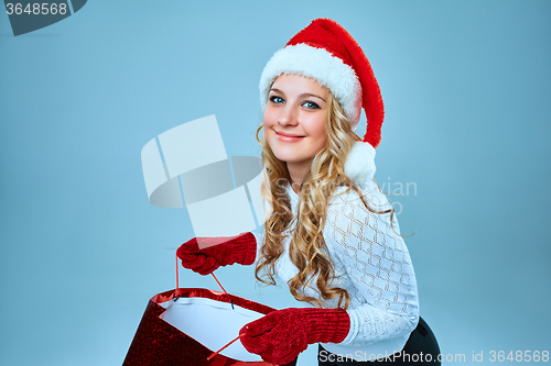 Image of Beautiful young woman in Santa Claus clothes
