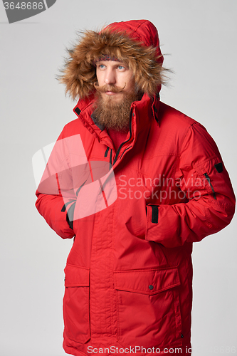 Image of Man wearing red winter Alaska jacket  with fur hood on