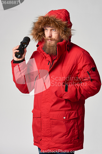 Image of Man wearing red winter Alaska jacket  with fur hood on