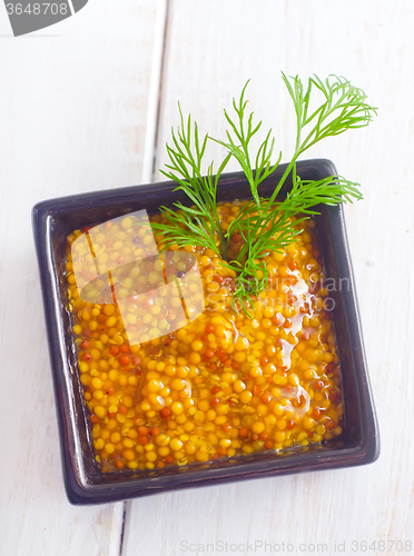 Image of Mustard in the black bowl on table