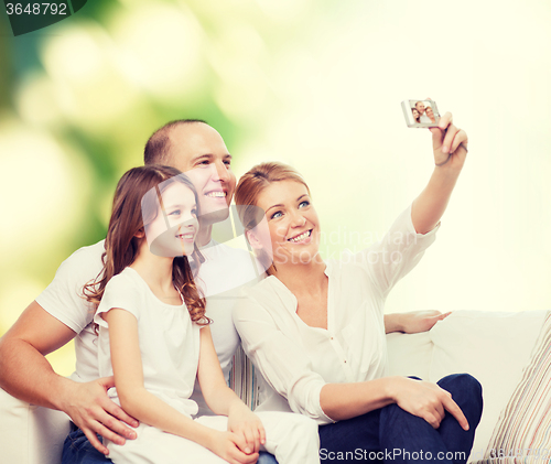 Image of happy family with camera at home