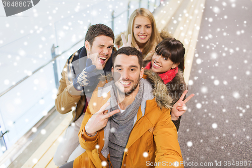 Image of happy friends taking selfie on skating rink