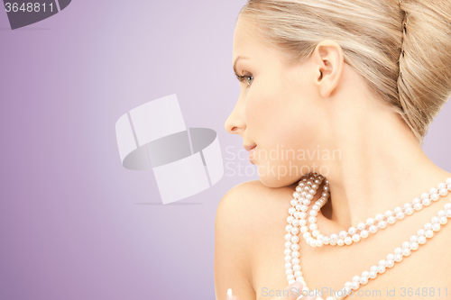 Image of beautiful woman with pearl necklace over violet