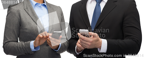 Image of businessman and businesswoman with smartphones