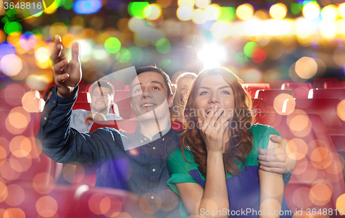 Image of happy friends watching movie in theater