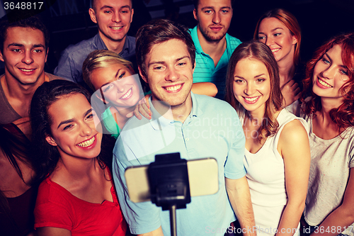 Image of friends with smartphone taking selfie in club