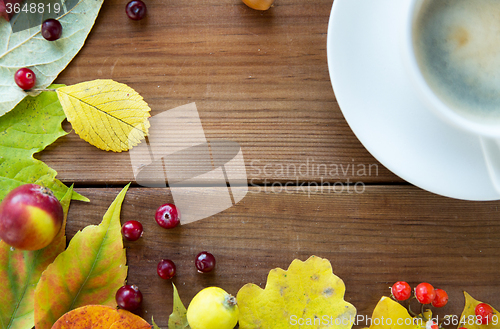 Image of close up of coffee cup on table with autumn leaves