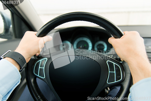 Image of close up of man driving car with computer screen