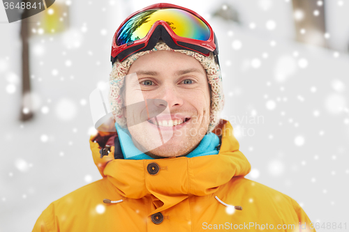 Image of happy young man in ski goggles outdoors