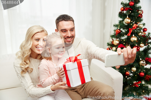 Image of family taking selfie with smartphone at christmas