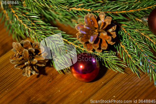 Image of fir branch with christmas ball and pinecones