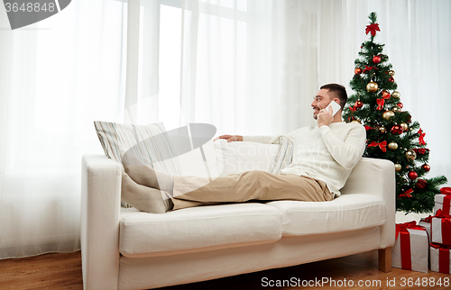 Image of man calling on smartphone at home for christmas