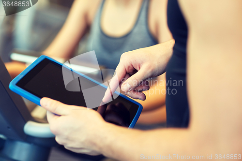 Image of close up of trainer hands with tablet pc in gym