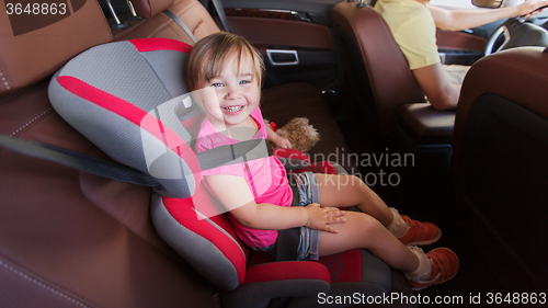 Image of happy child sitting in car seat and father driving