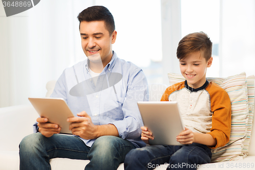 Image of happy father and son with tablet pc at home