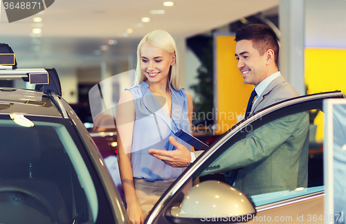 Image of happy woman with car dealer in auto show or salon