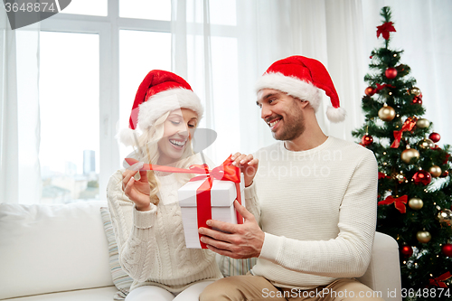 Image of happy couple at home with christmas gift box