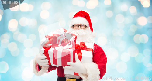 Image of man in costume of santa claus with gift boxes