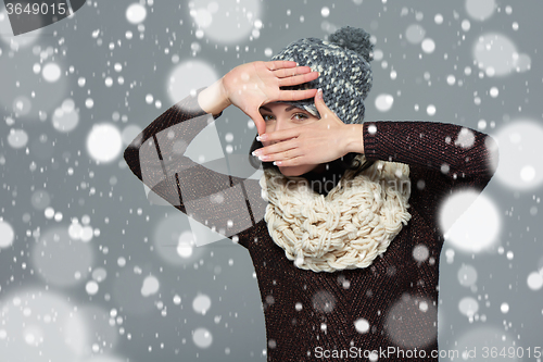 Image of Woman in winter clothing making a frame with her hands