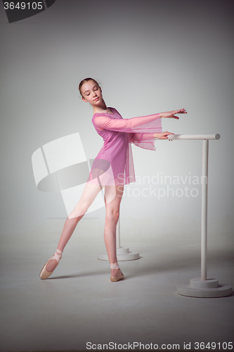 Image of The young ballerina stretching on the bar 