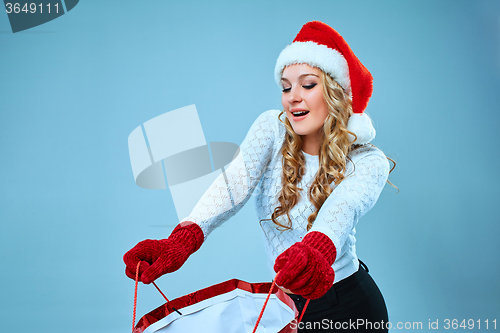 Image of Beautiful young woman in Santa Claus clothes
