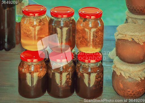 Image of Different varieties of honey in banks, offered for sale 