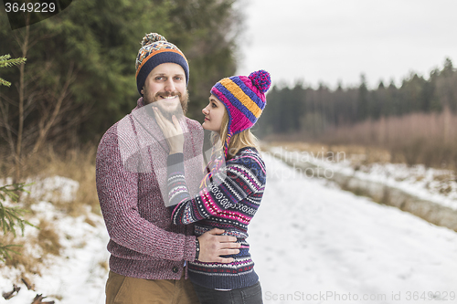 Image of Young couple hugging in winter forest