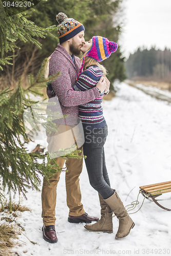 Image of Young peaople are kissing in winter forest