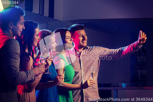 Image of friends with glasses and smartphone in club