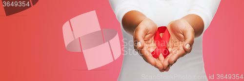 Image of close up of hands with red AIDS awareness ribbon