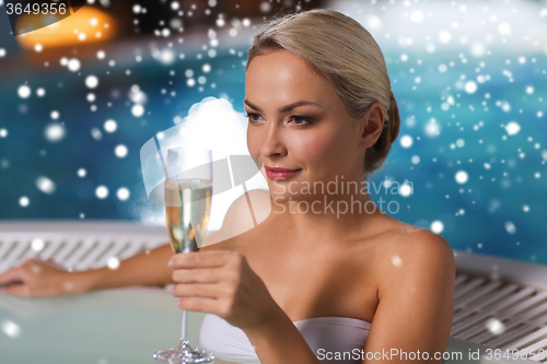 Image of happy woman drinking champagne at swimming pool