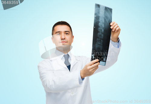 Image of male doctor in white coat holding x-ray