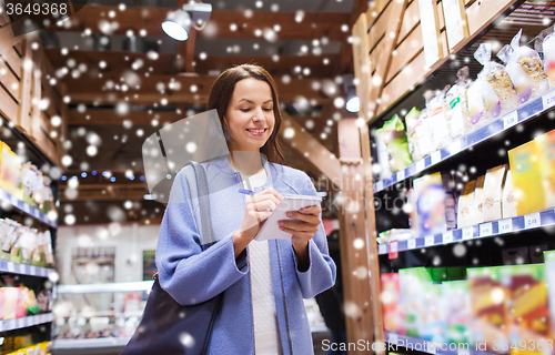 Image of happy woman with notepad in market