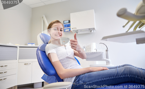 Image of happy patient girl showing thumbs up at clinic
